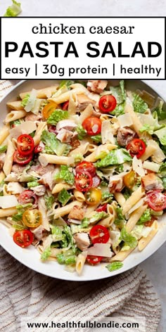 chicken caesar pasta salad with tomatoes and lettuce in a white bowl on a table