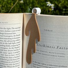 an open book with a wooden cutout of a person