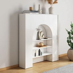 a living room with white furniture and a potted plant