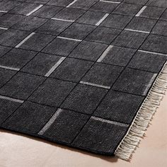 a black and white rug with fringes on the floor