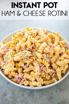 a white bowl filled with ham and cheese rotini pasta on top of a table