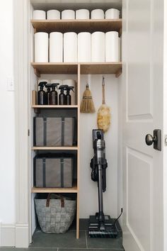 the shelves in this bathroom are filled with toiletries and cleaning supplies, along with two brooms