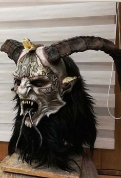 a horned mask with horns on top of a wooden table