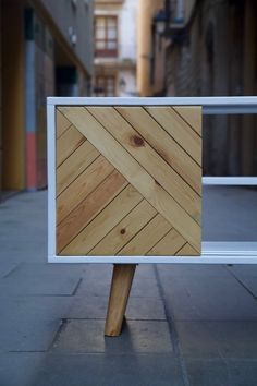 a wooden sign sitting on top of a sidewalk