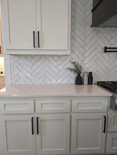 a kitchen with white cabinets and marble backsplashes on the counter top,