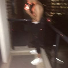 a blurry photo of a man standing on a stair case in front of a cityscape