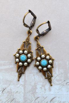 VINTAGE ELEMENTS Unique Jewellery, Handmade from Vintage Inspired, Original Designs. Tudor Style antiqued gold Earrings with Turquoise Blue Crystal  and Crystal Pearl detail. These Earrings have antiqued brass, floral leverback earwires  and measure 4.3cm from the top of the earwires. Turquoise Costume Jewelry Earrings For Gift, Vintage Blue Dangle Jewelry, Vintage Blue Drop Earrings Jewelry, Vintage Blue Dangle Earrings, Retro Jewelry With Matching Earrings For Vintage Collection, Vintage Blue Brass Earrings, Vintage Brass Jewelry With Turquoise, Vintage Blue Drop Earrings, Vintage Turquoise Brass Jewelry