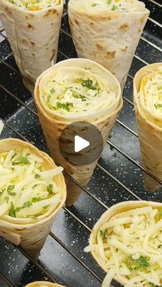 several burritos with cheese and herbs in them sitting on a cooling rack next to other burritos