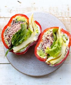 two stuffed peppers with meat and lettuce on them sitting on a white plate