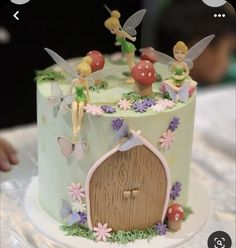 a cake decorated with tinkerbells and flowers