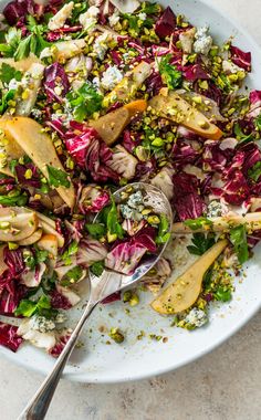 a salad with radishes, lettuce and other toppings in a white bowl