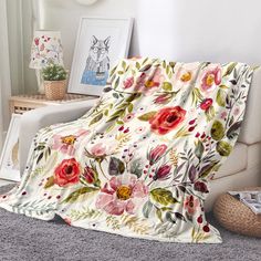 a blanket with flowers on it is sitting on the floor in front of a chair