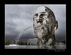 an artistic sculpture with water spouting out of it's face