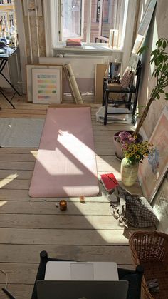 an open laptop computer sitting on top of a wooden floor next to a potted plant