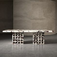 a marble table sitting on top of a cement floor next to a white chair and wall