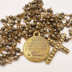 The brilliance of this necklace comes from the sparkling faceted pyrite beads on an antique gold chain. The grandeur of this three-tiered necklace arises from the cast bronze medal and coordinating cross pendant. The reverse side of the cross medal says, 'GOD is our refuge and strength, a very present help in trouble.' (Psalm 46:1) This length of this piece is adjustable from 29-32 inches and the cross measures 1.5 inches long. The splendor and nobility of God is rich and everlasting, and by rec Bronze Crucifix Necklace For Spiritual Purposes, Spiritual Bronze Crucifix Necklace, Gold Necklace With Oxidized Cross Pendant, Gold Spiritual Necklace With Oxidized Finish, Spiritual Gold Necklace With Oxidized Finish, Spiritual Gold Necklaces With Oxidized Finish, Gold Cross Necklace With Oxidized Finish, Psalm 46 1, Cross Medal