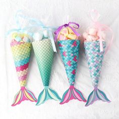 three little mermaid tail shaped candy cones with bows and ribbons on white paper towel background