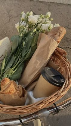 a basket filled with bread and flowers on top of a bike