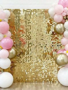 a gold and white backdrop with balloons