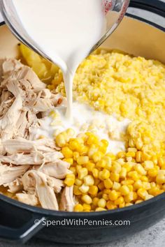 chicken, corn and mashed potatoes being poured into a pot with cream on top