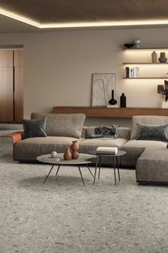 a living room filled with lots of furniture next to a wall mounted shelf above a coffee table