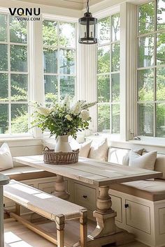 a sun room filled with lots of windows next to a wooden table and two benches