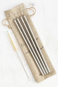 four stainless steel drinking straws in a pouch with a needle and thread on the side