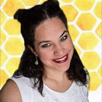 a woman smiling and wearing a white top with yellow honeycombs in the background