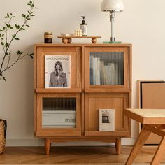 a wooden bookcase sitting next to a table with a potted plant on it