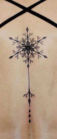 a woman's back with an arrow tattoo design on her left side ribcage