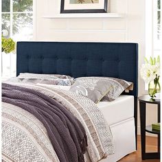 a bed with blue headboard and pillows in a room