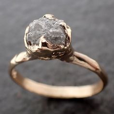 a gold ring with a rough diamond in the center