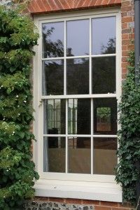 a brick building with ivy growing on it's side and an open window in the middle