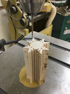 a piece of wood being cut into pieces with a milling machine in the back ground