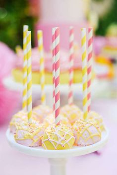 there are many desserts on the table with striped candles in them and one is yellow