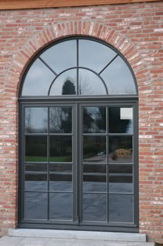 a brick building with arched glass doors on the outside