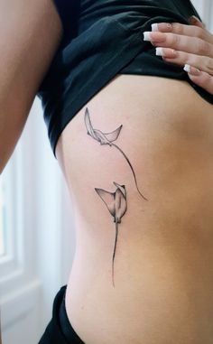 a woman's stomach with a flower tattoo on it