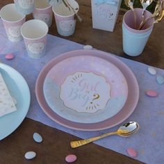 a pink and gold baby shower party set up with confetti on the table