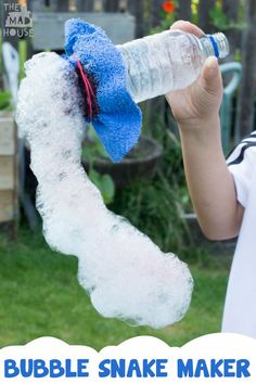 a person holding a water bottle in their hand with bubble snake maker attached to it