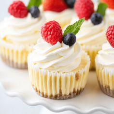 cupcakes with white frosting and fresh berries on top