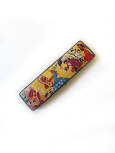 an old style lighter case with cartoon characters on the front and back sides, sitting on a white surface