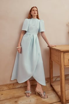 A beautifully tailored modern occasionwear dress. Our Delphine Dress in Ice Blue Cloqué is a sculpted beauty, creating the most enchanting look which is perfect for race days, summer weddings and special parties. Cut from a softly structured ice blue Italian cloqué cloth with an element of stretch for comfort and an exacting fit. Delphine has a timeless silhouette that creates impact with immaculate precision cutting and modern proportions. With a beautiful tulip shaped wrap skirt that is fixed British Wedding Guest Attire, Beautiful Blue Dresses, Suzannah London, Ice Blue Dress, Summer Dress Blue, Ice Dresses, Occasion Wear Dresses, Structured Dress, Tulip Dress