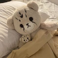 a teddy bear laying on top of a bed