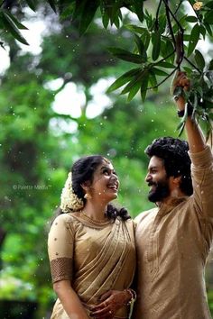 a man and woman standing under a tree in the rain