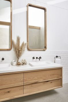 a bathroom with two sinks and mirrors on the wall