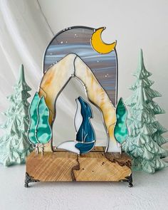 a wooden plaque with a blue and white animal on it's side in front of some trees