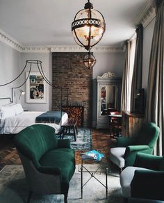 a living room filled with furniture and a fire place next to a brick wall covered in windows