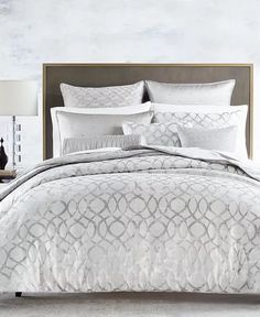 an image of a bed with white and grey comforter