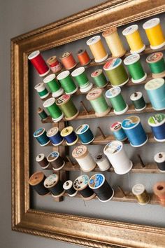 a wooden frame holding several spools of thread