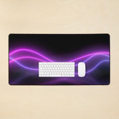 a computer mouse pad with a purple and black design on it, along with a white keyboard